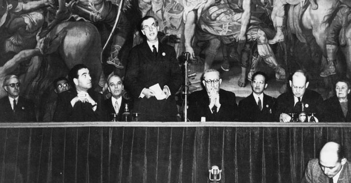 Prima Conferință Generală a UNESCO (19 noiembrie - 10 decembrie 1946). De la stânga: Jean Thomas (prezentat din lateral), Julian Huxley (fost director general, în picioare), Léon Blum (în dreapta microfonului) - foto preluat de pe en.unesco.org
