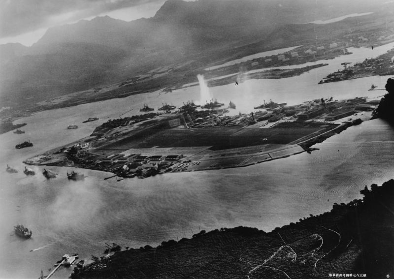 Photograph of Battleship Row taken from a Japanese plane at the beginning of the attack. The explosion in the center is a torpedo strike on USS West Virginia. Two attacking Japanese planes can be seen: one over USS Neosho and one over the Naval Yard - foto: en.wikipedia.org