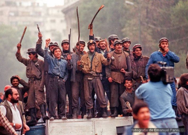 Grup de mineri aflați la București în timpul Mineriadei din iunie 1990, unii dintre ei ținând în mâini bâte și alte obiecte contondente.