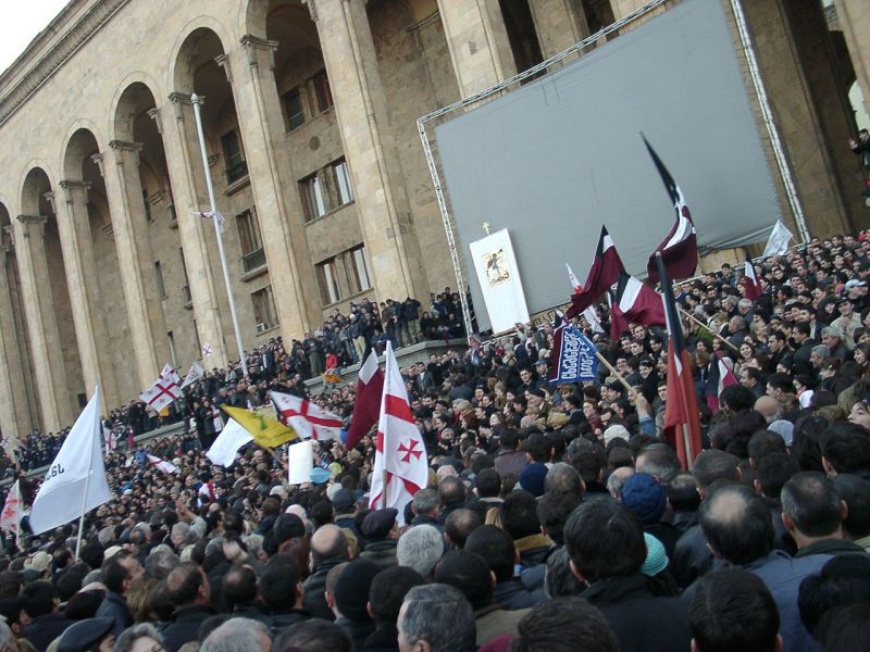 Revoluția Trandafirilor (3 - 23 noiembrie 2003) a fost o schimbare a puterii politice în Georgia în noiembrie 2003, care a avut loc după proteste în masă ca urmare a alegerilor parlamentare contestate. Ulterior, președintele Eduard Șevardnadze a fost forțat să demisioneze la data de 23 noiembrie 2003 (Proteste lângă sediul Parlamentului, în ziua demisiei lui Șevardnadze) - foto preluat de pe ro.wikipedia.org