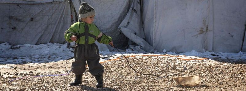 A child plays with a homemade sled made from an empty container and a length of cable, in Roj Camp, northeast Syria, February 2020. Photo: ©UNICEF/UNI310464/Romenzi - foto preluat de pe www.un.org